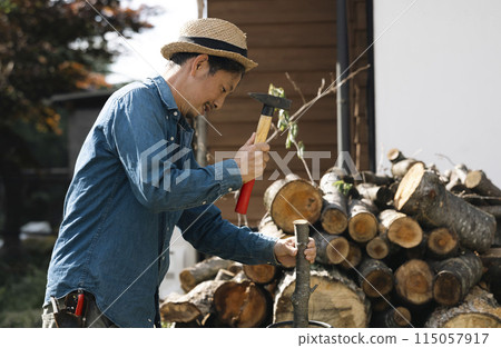 A man breaking firewood 115057917