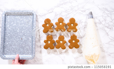 Flat lay. Gingerbread cookies await their second halves on a marble surface, each meticulously piped with buttercream to craft delightful sandwich treats. The precision of the piping adds a festive Flat lay. Gingerbread cookies await their second halves on a marble surface, each meticulously piped with buttercream to craft delightful sandwich treats. The precision of the piping adds a festive 115058191