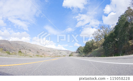 Vehicle is cruising along the Cuyama Highway under the bright sun. The surrounding landscape is illuminated by the radiant sunshine, creating a picturesque and inviting scene as the car travels Vehicle is cruising along the Cuyama Highway under the bright sun. The surrounding landscape is illuminated by the radiant sunshine, creating a picturesque and inviting scene as the car travels 115058228
