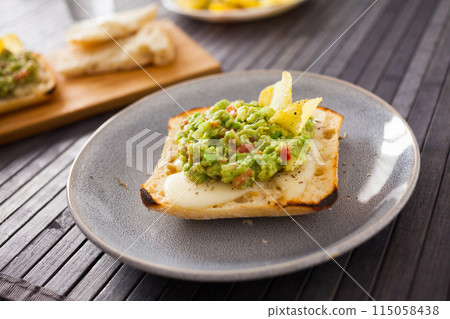 Morning toast with melted cheese and guacamol Morning toast with melted cheese and guacamol 115058438