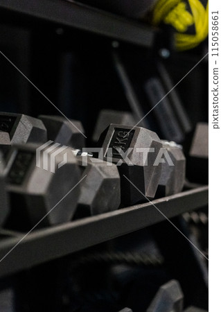 In a gym, a shelf displays a set of dumbbells for weightlifting In a gym, a shelf displays a set of dumbbells for weightlifting 115058661