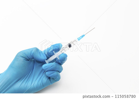 Hand holding a syringe 115058780