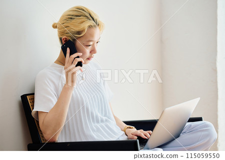 A woman operating a smartphone at home A woman operating a smartphone at home 115059550