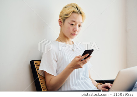 A woman operating a smartphone at home 115059552
