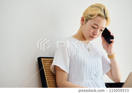 A woman operating a smartphone at home 115059553