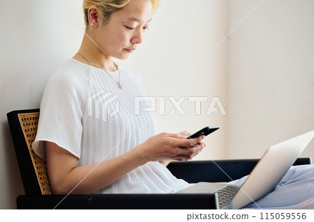 一位女士在家中操作智慧型手機 一位女士在家中操作智慧型手機 115059556