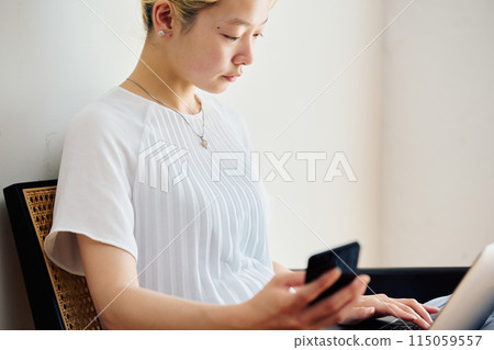A woman operating a smartphone at home A woman operating a smartphone at home 115059557