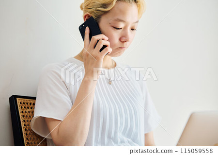 A woman operating a smartphone at home A woman operating a smartphone at home 115059558