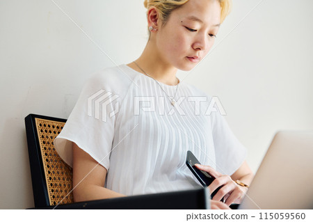 A woman operating a smartphone at home A woman operating a smartphone at home 115059560