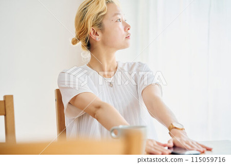 A woman taking a break while working from home A woman taking a break while working from home 115059716