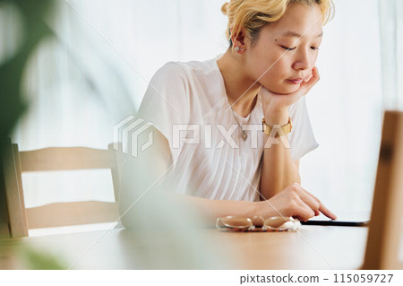 A woman taking a break while working from home 115059727