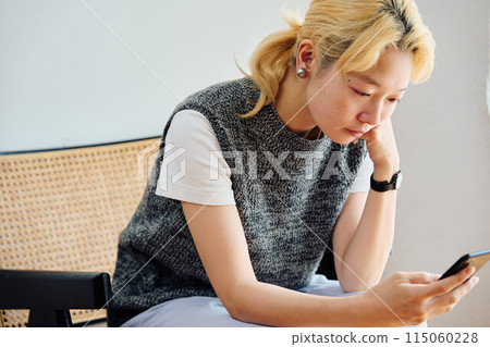 A woman who operates a smartphone in the room 115060228