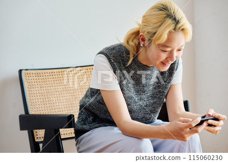 A woman who operates a smartphone in the room A woman who operates a smartphone in the room 115060230
