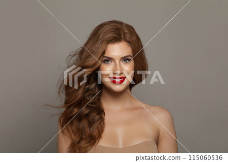 Stylish fashionable redhead woman with long wavy hair and make-up. Studio headshot portrait  115060536
