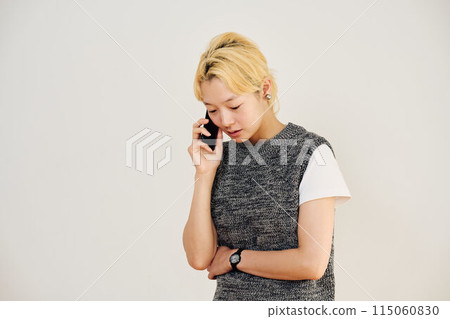 Portrait of a blonde woman making a phone call Portrait of a blonde woman making a phone call 115060830