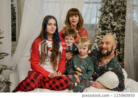 A large family with children posing in pajamas in New Year's locations. 115060950