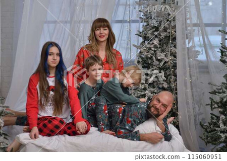 A large family with children posing in pajamas in New Year's locations. A large family with children posing in pajamas in New Year's locations. 115060951
