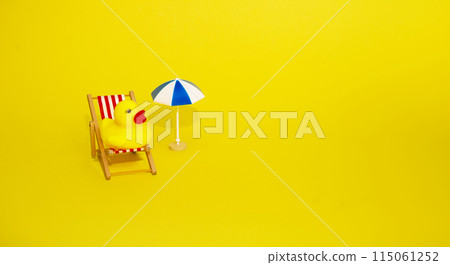 Beach relaxation and vacation concept. Toy sun lounger, duck and umbrella on yellow colorful paper background. 115061252