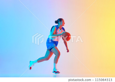Sportive woman in blue basketball jersey dribbling in motion in neon light against gradient studio background. Sportive woman in blue basketball jersey dribbling in motion in neon light against gradient studio background. 115064313