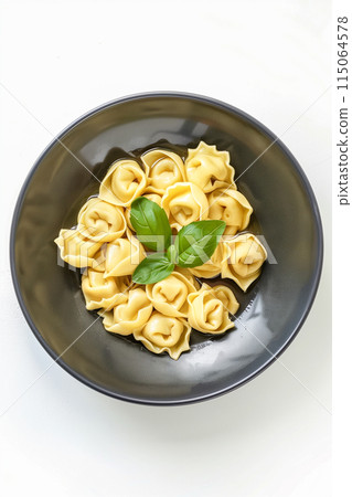 A plate of pasta with a green leaf on top 115064578