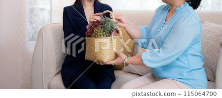 Young asian woman agent insurance visit customer elderly while giving fruit basket. Young asian woman agent insurance visit customer elderly while giving fruit basket. 115064700