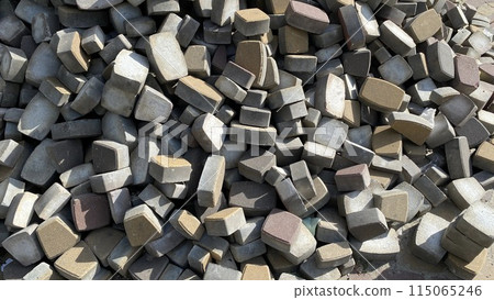 Concrete paving slabs on a construction site in a heap, old bricks for a pedestrian road, construction waste Concrete paving slabs on a construction site in a heap, old bricks for a pedestrian road, construction waste 115065246