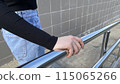 Close up photo of woman hand holding onto steel handrail of staircase on the street, grabbing the handrail 115065266