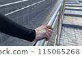 Girl hand holds metal handrail on street ramp for balance, safe movement on the street 115065268