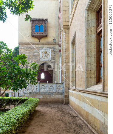 Serene view of a rustic style building featuring an arched balcony, and detailed window grills 115065375