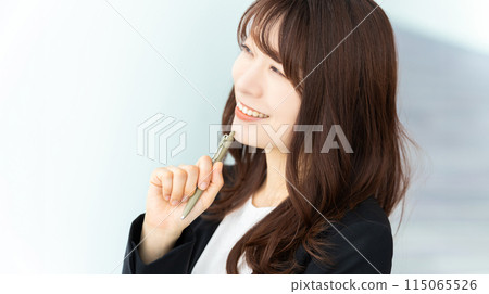Smiling business woman holding a pen 115065526