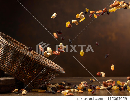 Dried fruits and nuts fall in basket. 115065659