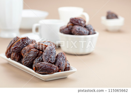 Dates in white dish on a beige background. 115065662