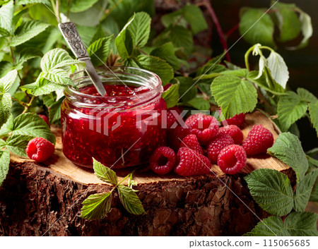 Jar of raspberry jam and fresh berries with leaves. Jar of raspberry jam and fresh berries with leaves. 115065685