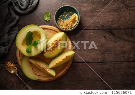 Cantaloupe, melon fruit slice over dark background. Healthy snack or dessert Cantaloupe, melon fruit slice over dark background. Healthy snack or dessert 115066071
