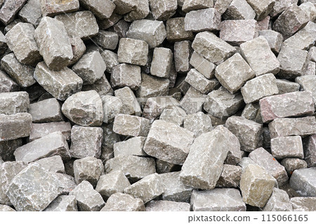 Pile of historic cube shape natural granite cobblestones, background of hammered granite rocks 115066165