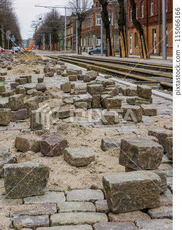 Historic cube-shaped hammered natural granite paving stones on an unfinished street pavement Historic cube-shaped hammered natural granite paving stones on an unfinished street pavement 115066166