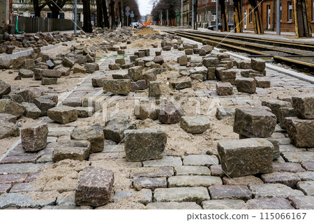 Historic cube-shaped hammered natural granite paving stones on an unfinished street pavement Historic cube-shaped hammered natural granite paving stones on an unfinished street pavement 115066167