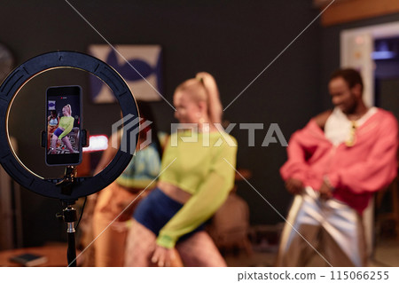 Trendy dance crew recording videos for social media or livestream with focus on ring light in foreground copy space Trendy dance crew recording videos for social media or livestream with focus on ring light in foreground copy space 115066255