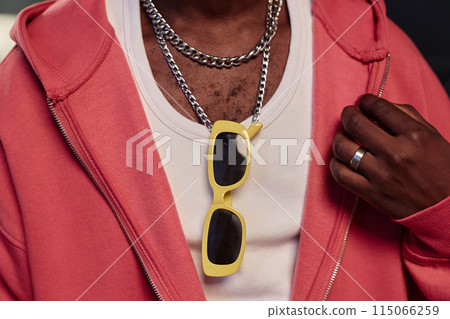 Close up detail shot of unrecognizable Black man wearing trendy sunglasses on neck and chain accessories copy space Close up detail shot of unrecognizable Black man wearing trendy sunglasses on neck and chain accessories copy space 115066259