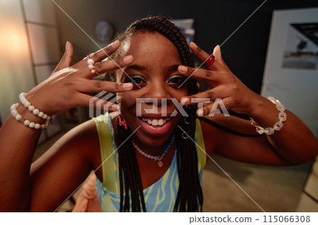 FIsheye POV of Black young woman dancing indoors recording video for social media and smiling at camera FIsheye POV of Black young woman dancing indoors recording video for social media and smiling at camera 115066308