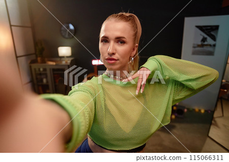 POV shot of blonde young woman wearing trendy outfit taking selfie photo or recording video for social media indoors copy space POV shot of blonde young woman wearing trendy outfit taking selfie photo or recording video for social media indoors copy space 115066311