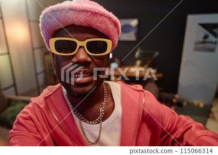 POV shot of African American man wearing pink outfit with sunglasses recording video for social media indoors copy space 115066314