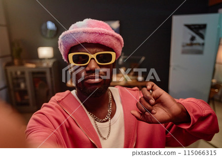 POV of Black man taking selfie photo or recording video for social media while wearing pink trendy outfit copy space 115066315