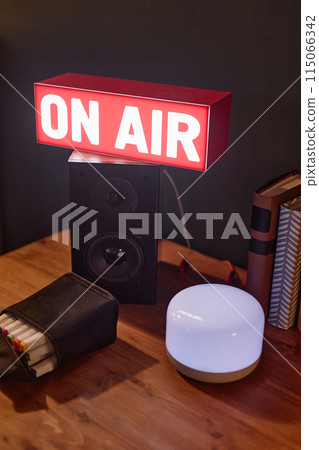 Vertical background image of still life composition with light up On air sign and speakers copy space 115066342