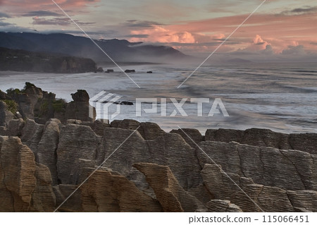Ocean beach cliffs and mist in New Zealand 115066451