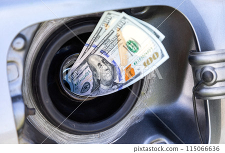 American dollars bills in the gas tank of a vehicle. Concept photo of the rising fuel price 115066636