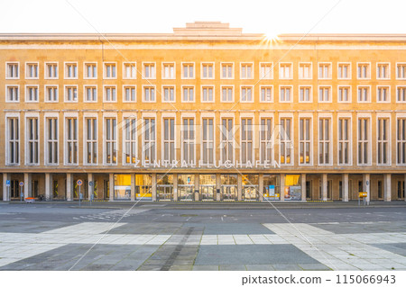 Sunlight flares above the historic Tempelhof Airport terminal in Berlin, casting a warm glow on its facade. 115066943