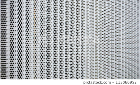 Background photo of a close-up of a white perforated metal fence 115066952