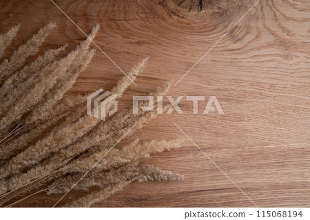 A pile of dried grass is placed on a wooden table 115068194