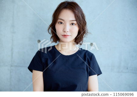 Woman sitting on a chair against a concrete background 115069096